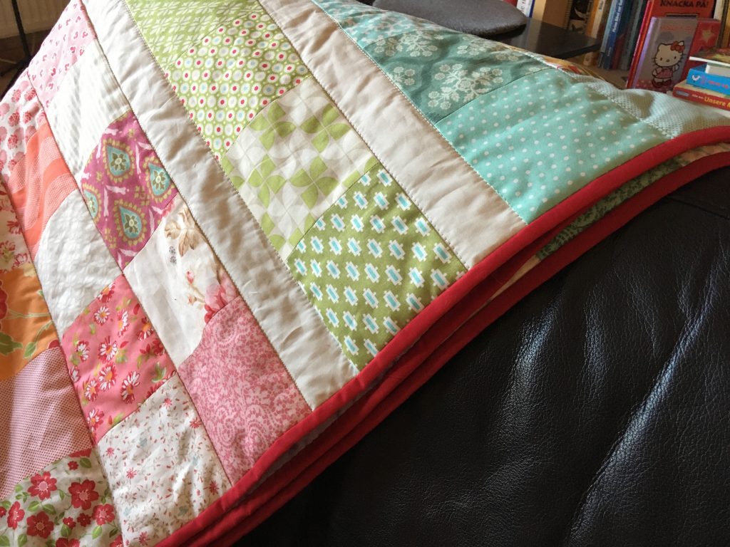 Charm Pack Quilt mit Jelly Roll Stripes als Zwischentrenner